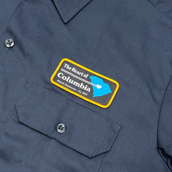 A close up of a Bluetile Skateboards "HEART OF COLUMBIA" work shirt navy.