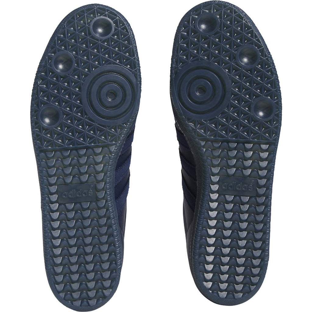 A pair of ADIDAS X ORCHARD SAMBA ADV NIGHT INDIGO / SILVER shoes with black soles.