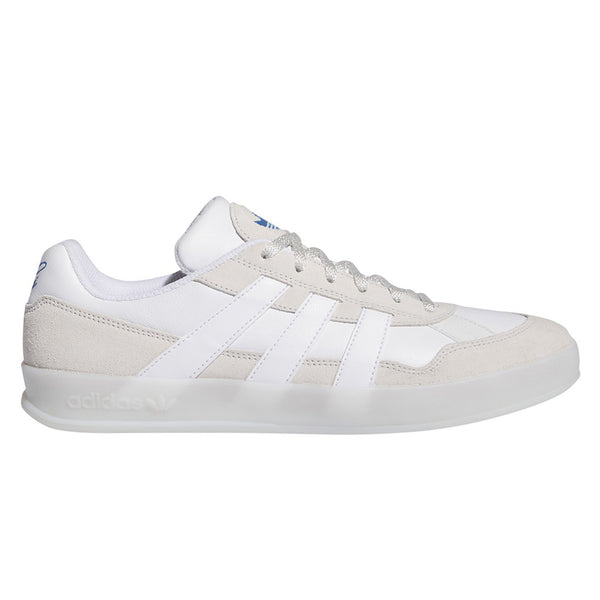 A white and ivory colored shoe with a clear/white sole.