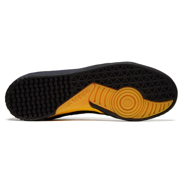 Bottom view of a black and yellow ADIDAS COPA PREMIERE CORE BLACK / ZERO METALLIC / SPARK sneaker sole, showcasing a combination of triangular and circular tread patterns for traction.