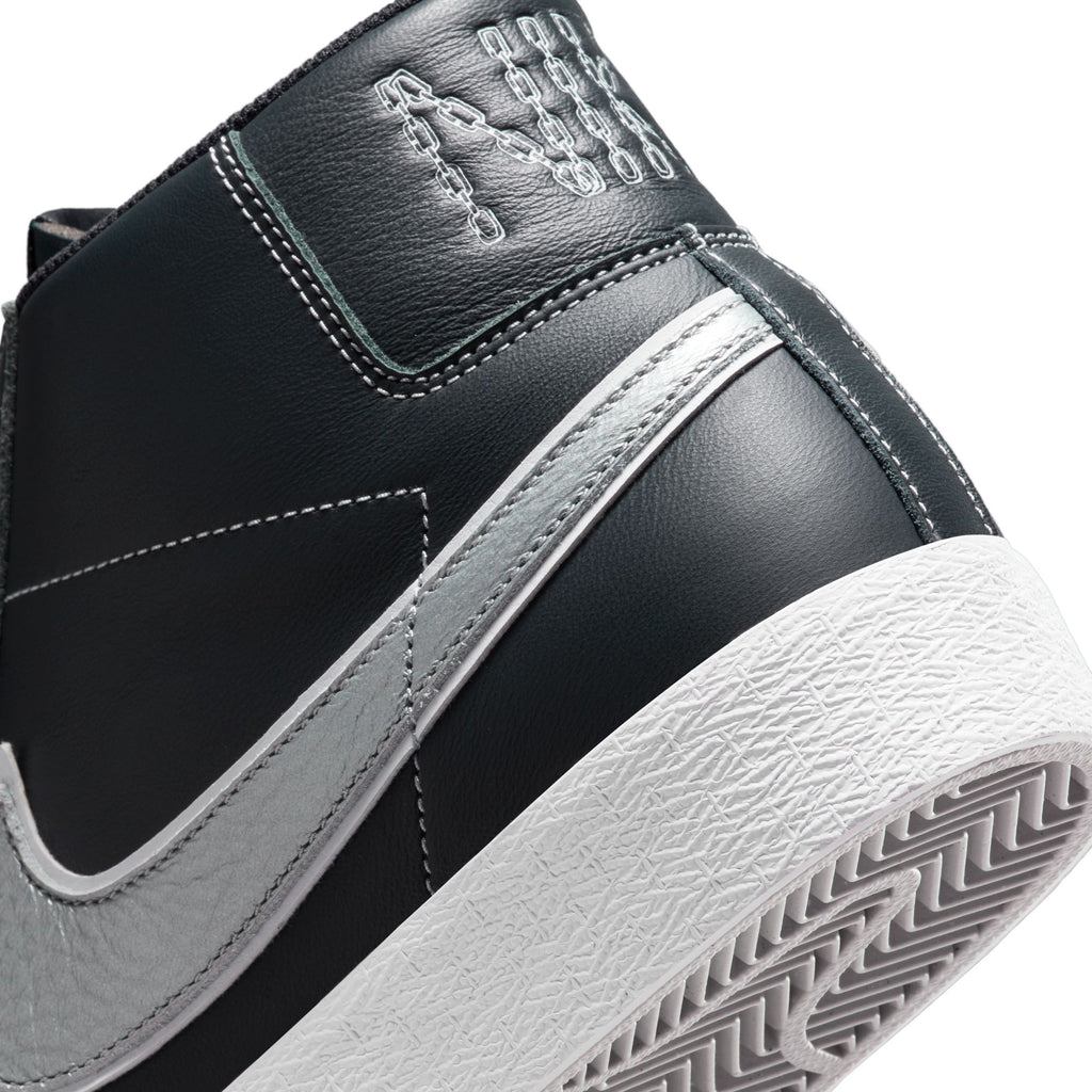 A close up of a black and silver Nike SB Blazer Mid X Mason Silva Blacked Blue/Wolf Grey sneaker.