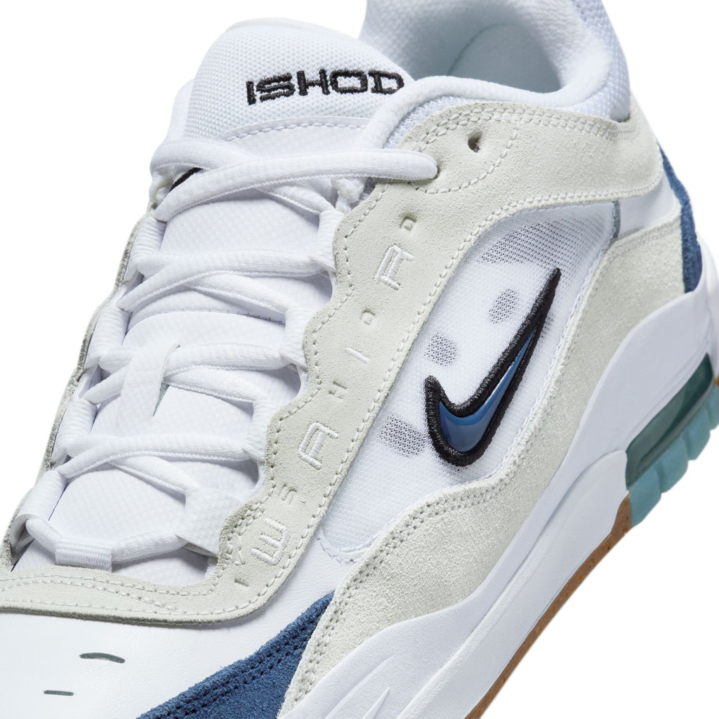 Close-up of a white and VARSITY RED sneaker with "NIKE SB ISHOD 2 AIR MAX WHITE / NAVY-SUMMIT WHITE-BLACK" text on the tongue and a small black swoosh logo from nike.