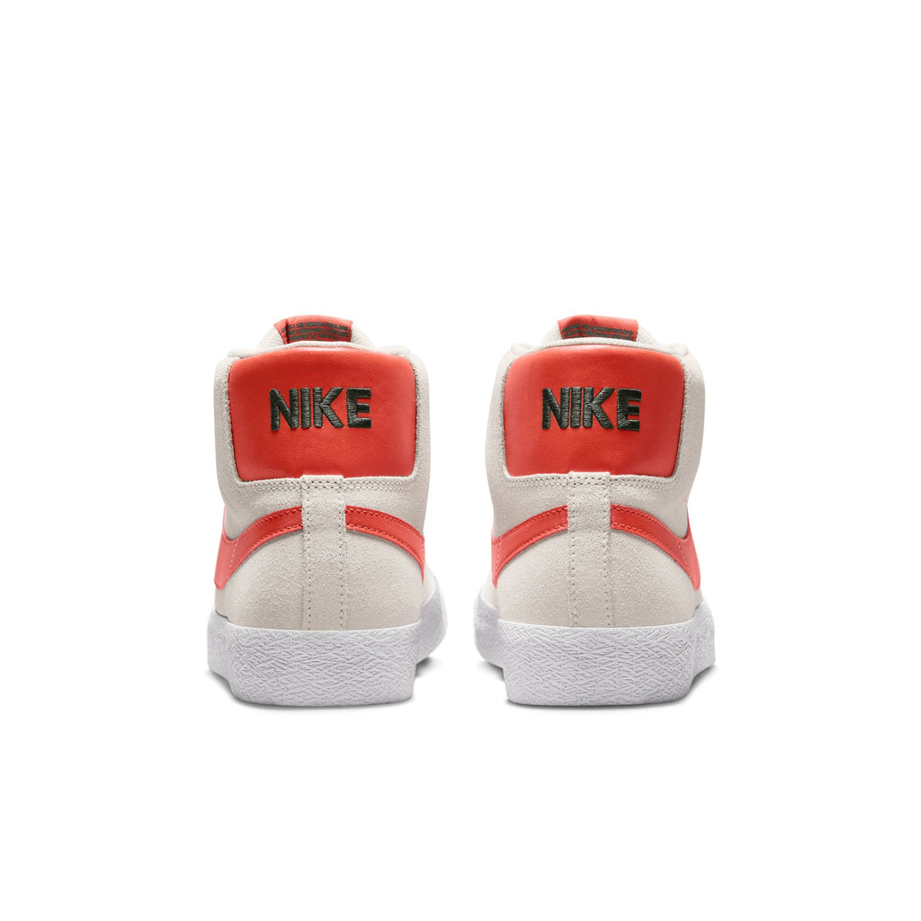 Rear view of a pair of nike SB Blazer Mid Phantom / Cosmic Clay skateboarder shoes with white soles and red accents.