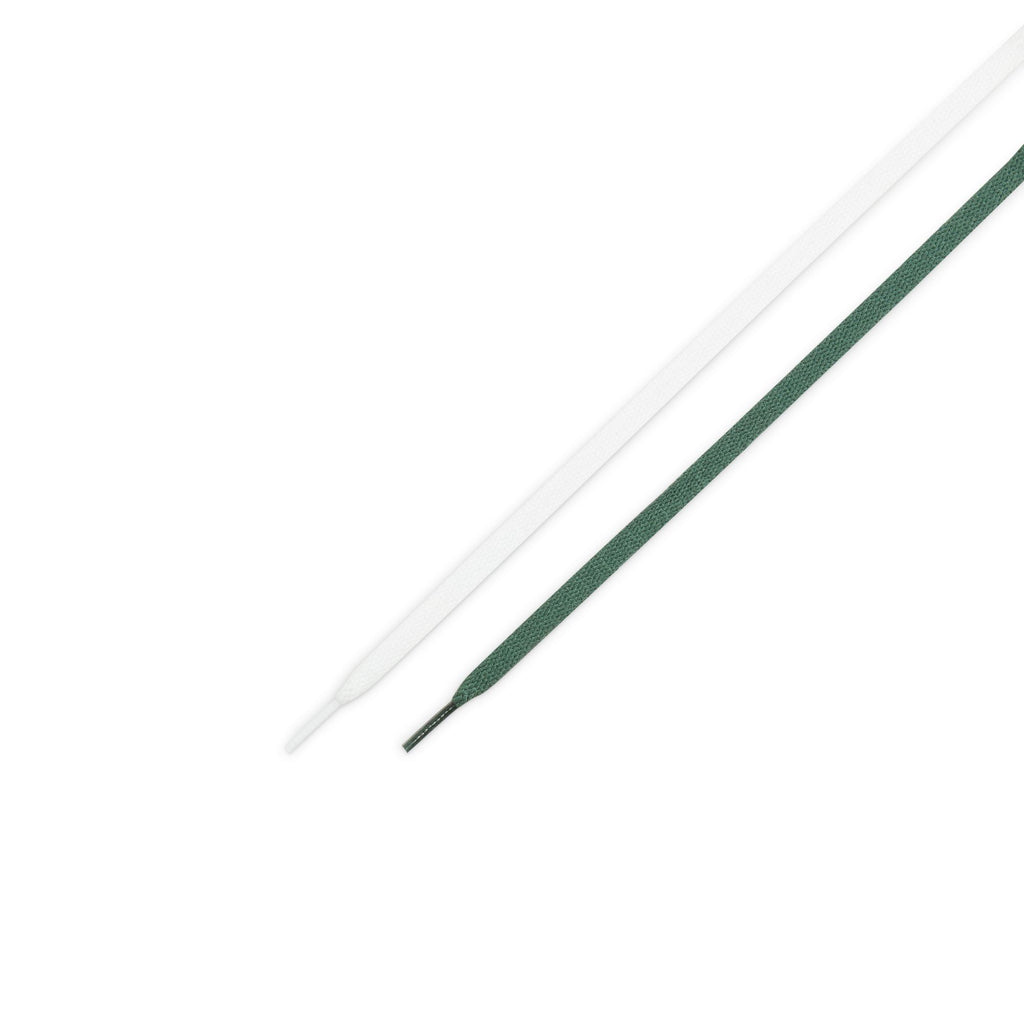 A pair of green and white nike SB Blazer Mid Fir / White skate shoes on a white surface.