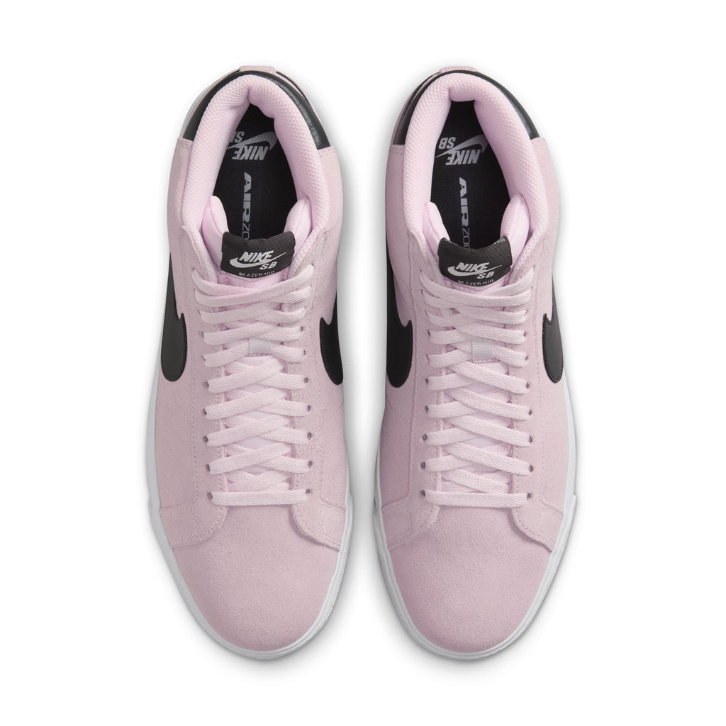 Top view of a pair of nike SB Blazer Mid Pink Foam/Anthracite-White-Gum Yellow sneakers with black swooshes, white midsoles, and a suede upper, placed side by side on a white background.