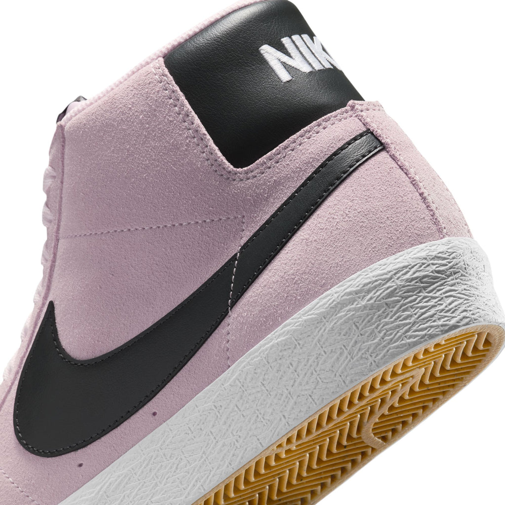 Close-up of the nike NIKE SB BLAZER MID PINK FOAM/ANTHRACITE-WHITE-GUM YELLOW, featuring a pink suede upper, black swoosh, white midsole, yellow gum sole, and Zoom Air cushioning for comfort.