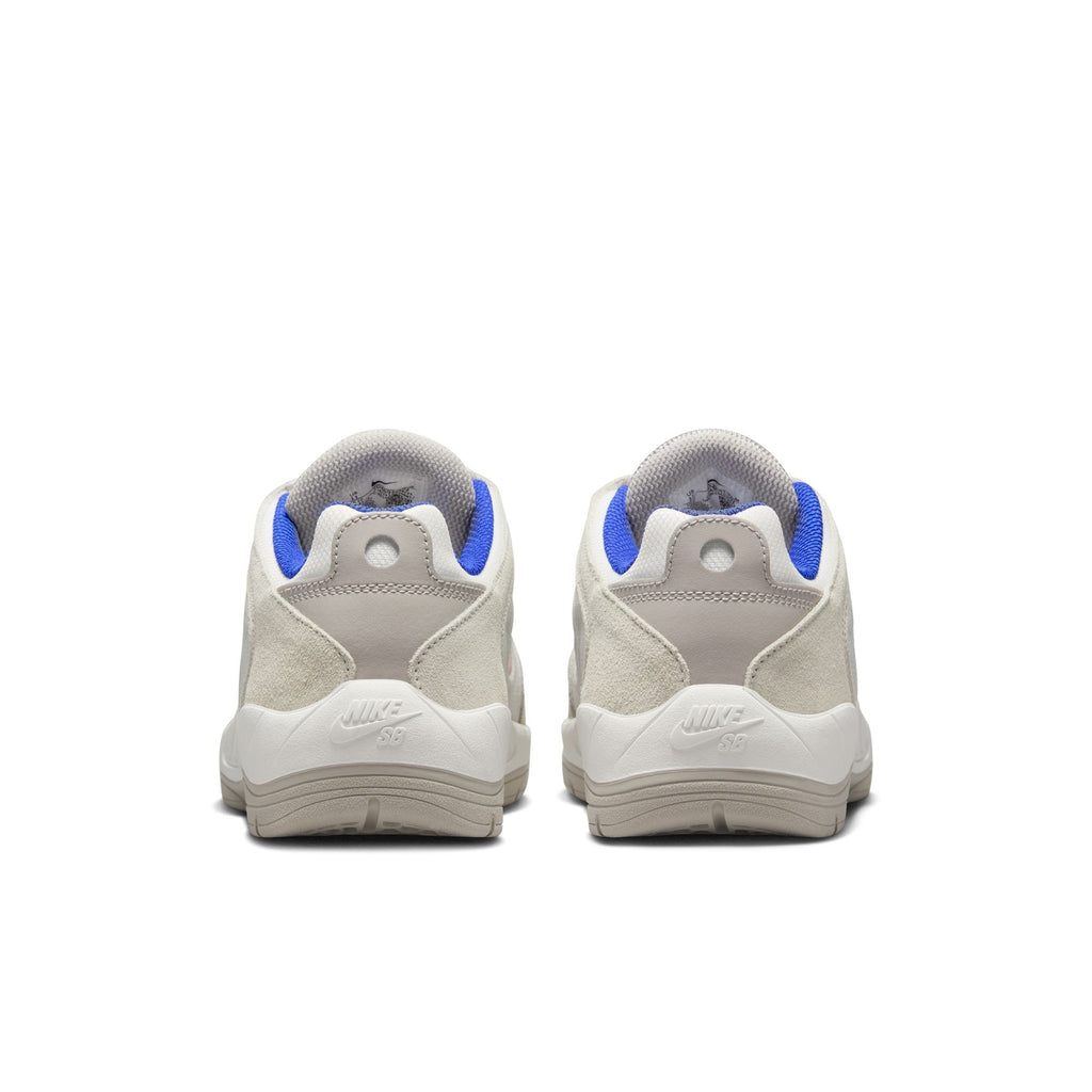A pair of nike SB VERTEBRAE SUMMIT WHITE/COSMIC CLAY sneakers seen from the heel view, featuring white and blue accents with color blocking.
