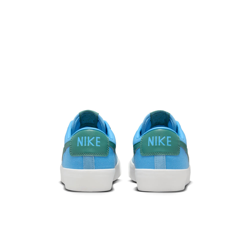 A pair of blue and white Nike SB Blazer Low Pro University Blue/Bicoastal sneakers photographed from the rear view, featuring Zoom Air cushioning.
