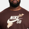 Close-up of a person wearing a brown nike NIKE SB 'CITY OF LOVE' LS SKATE TEE EARTH with a graphic design.