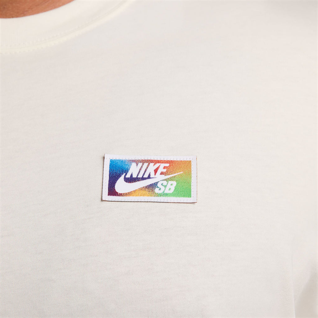Close-up of a men's white nike skate tee featuring a colorful NIKE SB logo patch on the chest.