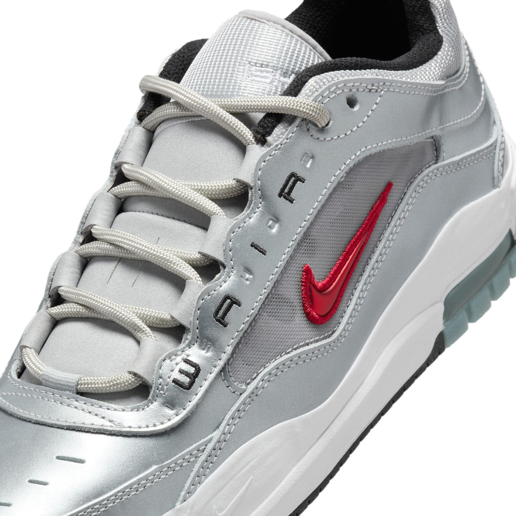 The NIKE SB ISHOD 2 AIR MAX sneaker by Nike boasts a metallic silver design with a varsity red swoosh, enhanced by black accents, a white sole, and gray laces.
