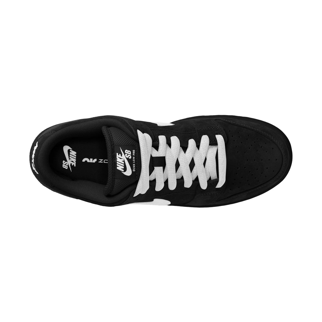 Top view of the NIKE SB DUNK LOW PRO in black, white, and gum light brown, crafted with premium materials and featuring white laces on a pristine white background.
