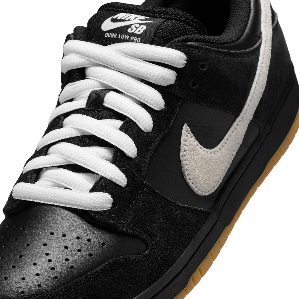 The NIKE SB DUNK LOW PRO BLACK / WHITE-BLACK-GUM LIGHT BROWN sneaker combines black and white suede with a brown gum sole for enhanced traction.
