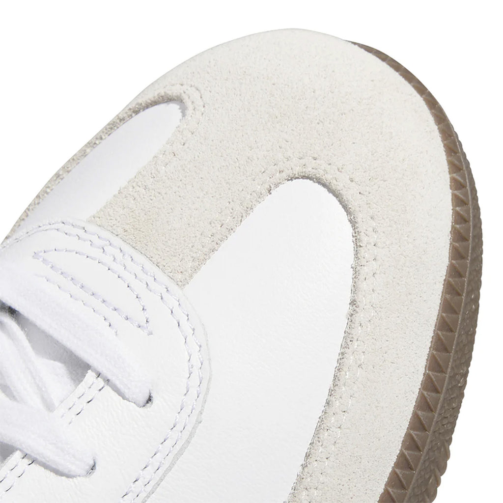 Close-up of the toe area of an Adidas Samba ADV Cloud White / Collegiate Purple skateboarding shoe, featuring suede and leather materials, with white laces and a textured rubber sole, enhanced by the signature Adituff toe reinforcement.
