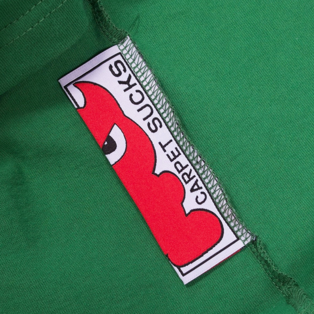 An inside tag of the shirt that says "CARPET SUCKS" with a little red devil character.