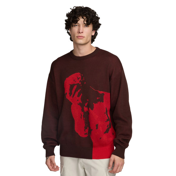 A man wearing a nike 'City of Love' knit sweater brown/earth with a man's face on it.