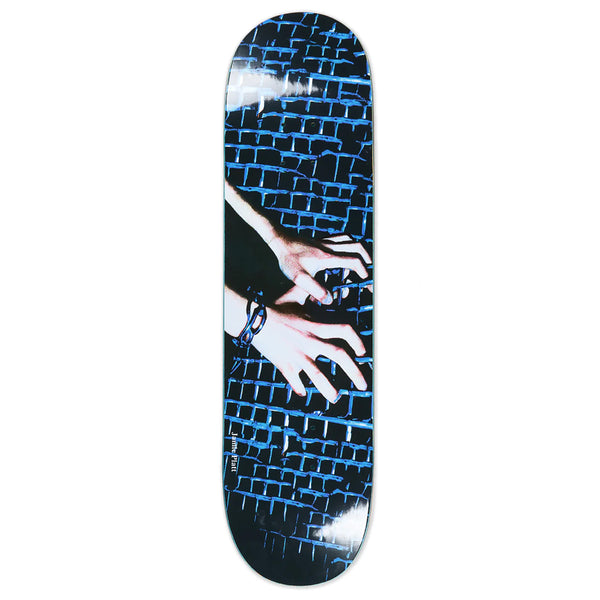 A skateboard deck with an image of chained hands holding onto a fence.