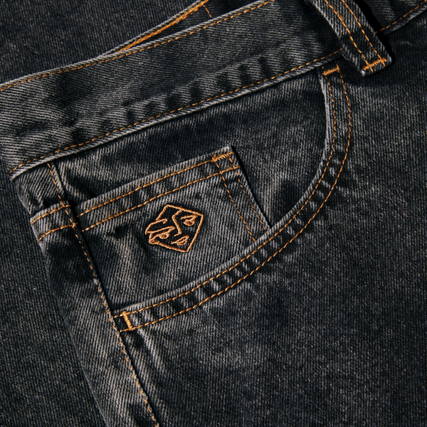 Close-up of a POLAR '89 DENIM WASHED BLACK jeans pocket with orange stitching and a small brown label stating "POLAR '89.