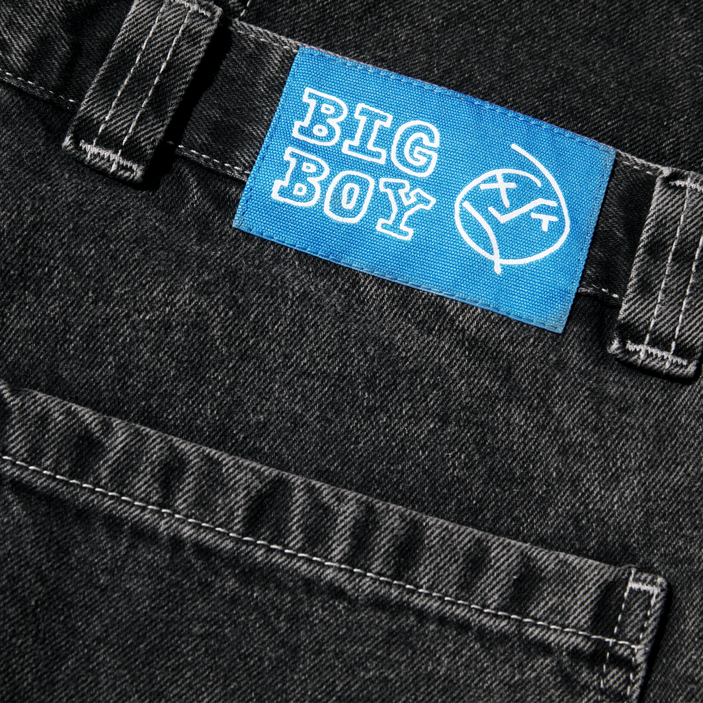 Close-up of a blue "POLAR BIG BOY DOUBLE KNEE WORK PANT DOUBLE KNEE" label sewn onto black fabric.