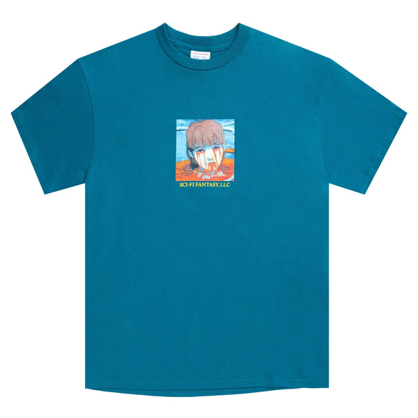 A teal tee with a drawing of a persons cut off head and blood dripping on their face.