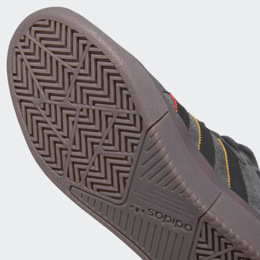 A pair of ADIDAS TYSHAWN CARBON / CORE BLACK / PRELOVED BROWN sneakers with a grey and yellow sole.