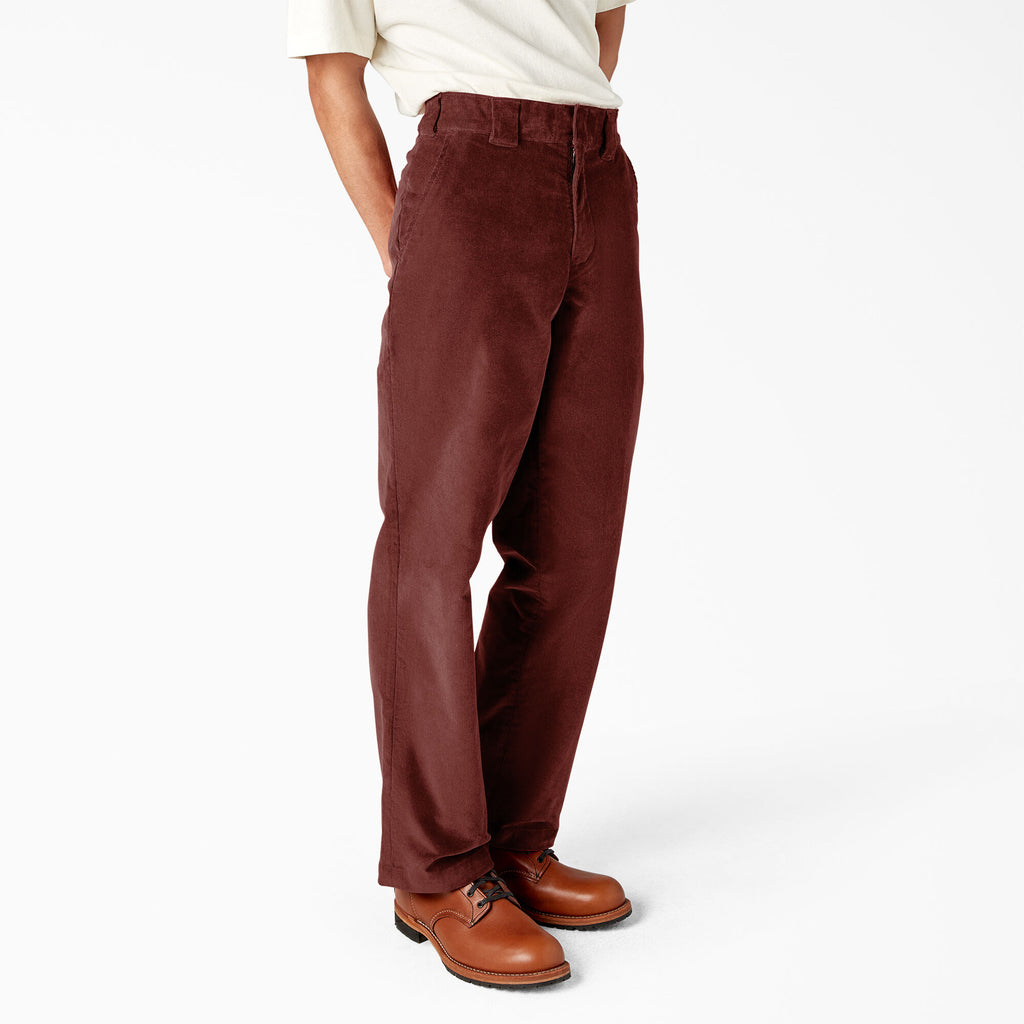 A man wearing DICKIES REGULAR FIT CORDUROY PANT FIRED BRICK pants from the brand DICKIES.
