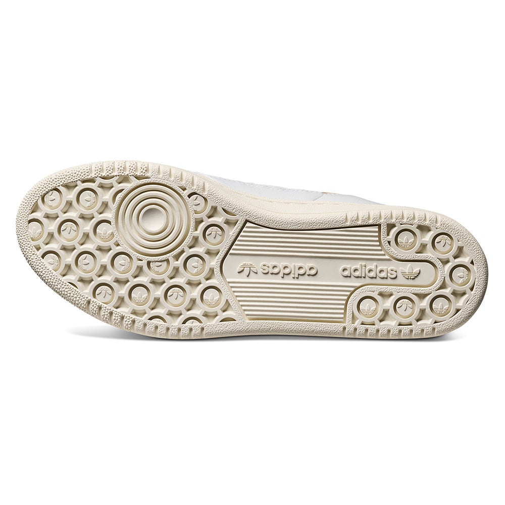 The image displays the outsole of the ADIDAS CENTENNIAL 85 LOW ADV CRYSTAL WHITE / SHADOW NAVY, featuring a textured tread with circular grips and central ADIDAS branding, offering excellent traction for skateboarding.