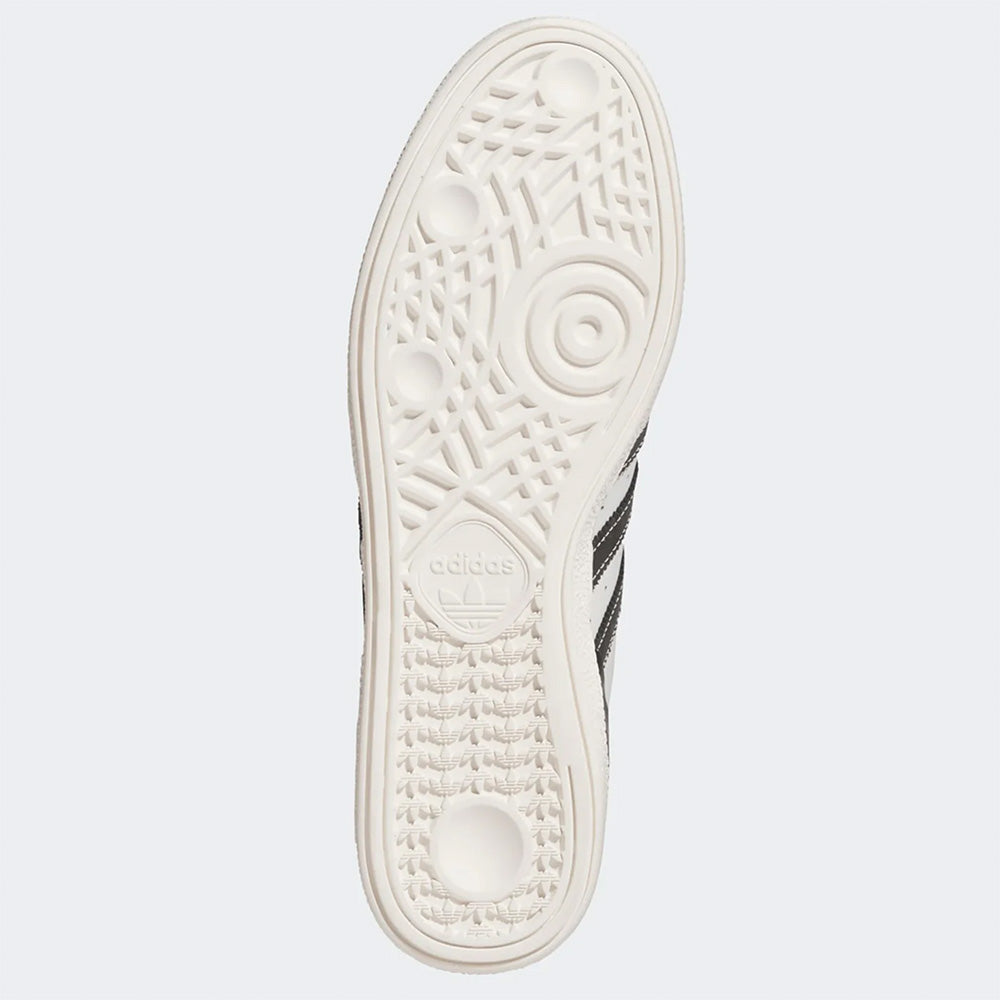 The image displays the sole of the ADIDAS BUSENITZ CRYSTAL WHITE / BLACK / OFF WHITE sneaker, featuring a textured, patterned tread and the ADIDAS logo stamped near the center.