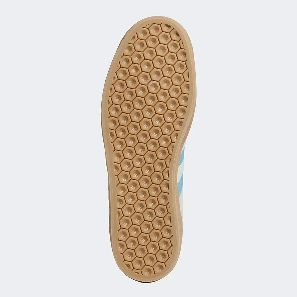 The vulcanized rubber outsole of the ADIDAS GAZELLE ADV WONDER WHITE / BLUE / GUM sneaker features a honeycomb pattern and light brown finish, shown from below against a plain background.