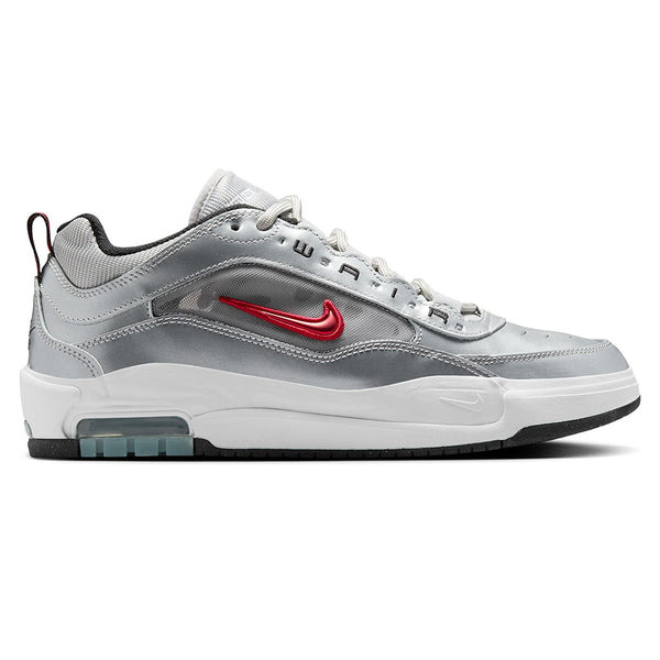 The NIKE SB ISHOD 2 AIR MAX sneaker by Nike boasts a sleek metallic silver and white design, complemented by a bold varsity red swoosh logo, black accents, and a transparent heel panel.