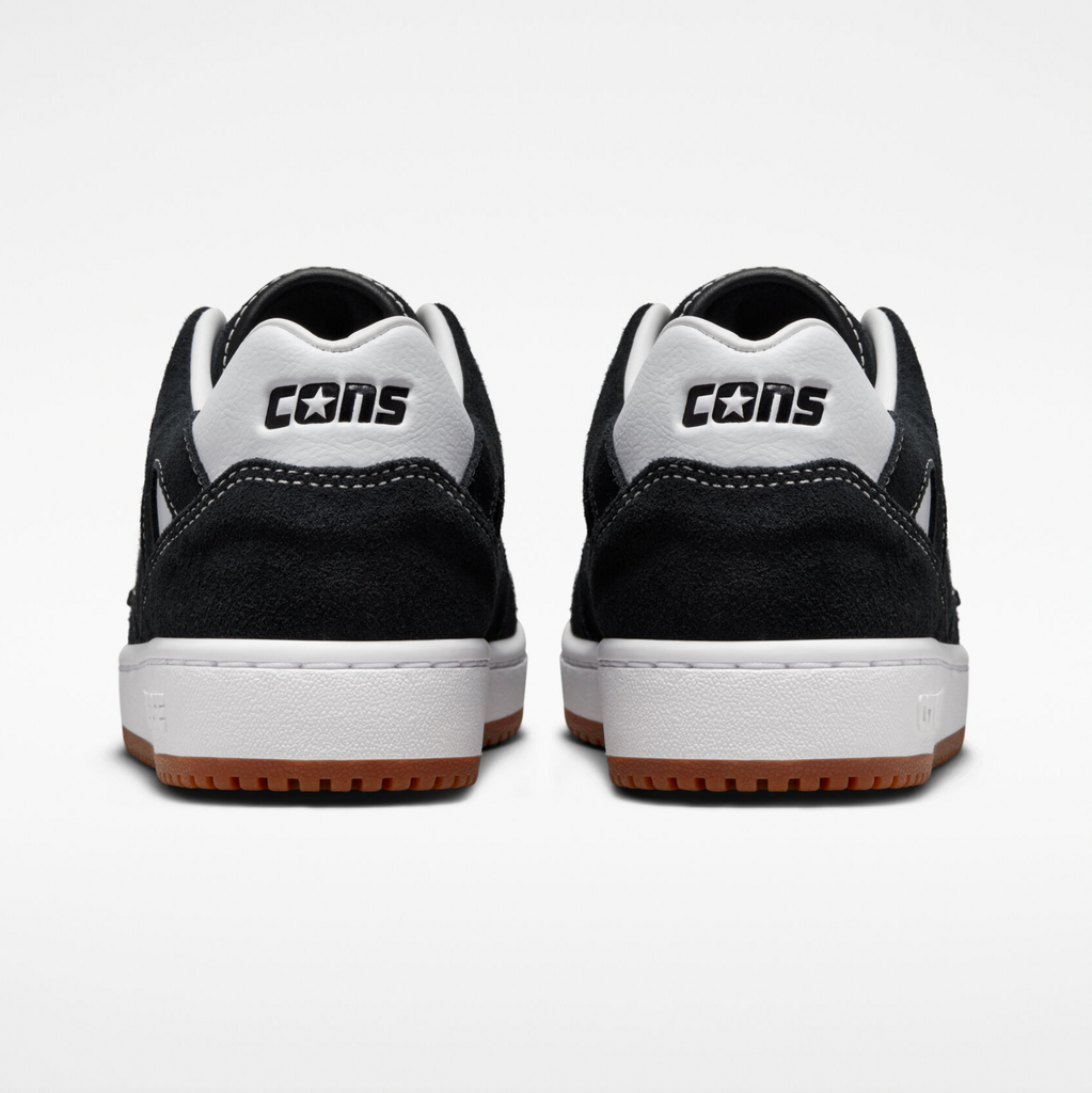 A pair black white shoes from the back view that says cons.