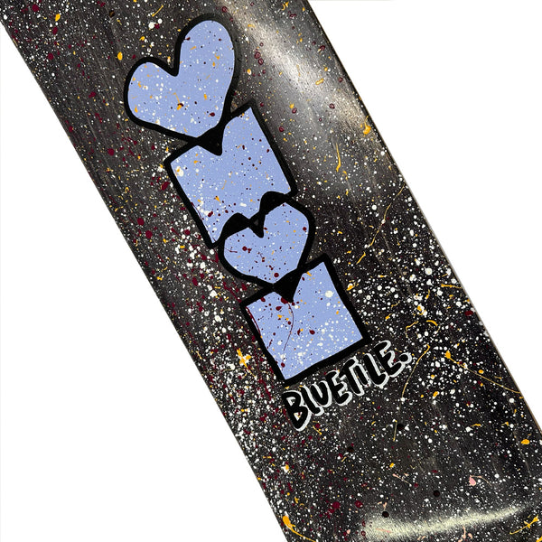 The BLUETILE HEART + SQUARE SPLATTER DECK by Bluetile Skateboards features a black background with colorful splatters, Jay Croft’s "AMOR" in blue block letters with hearts, and "BUENIE" written below.