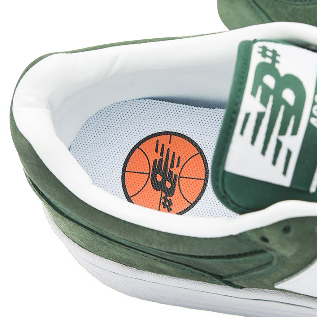Close-up of a NB NUMERIC 480 FOREST GREEN / WHITE sneaker featuring a basketball and handprint logo on the ABZORB in-sole.