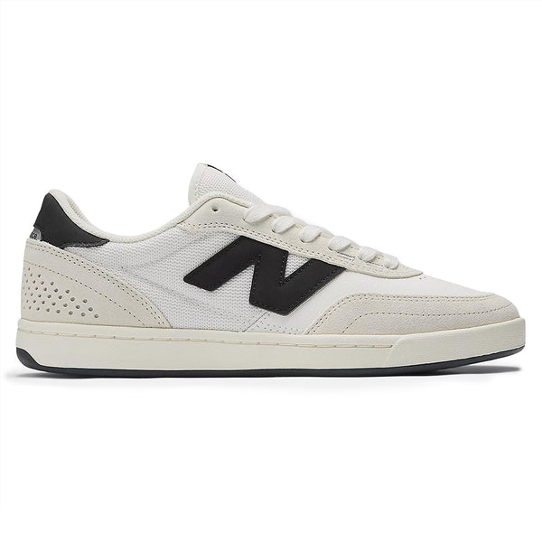 The NB NUMERIC 440 V2 SEA SALT / BLACK sneaker, with a black "N" logo, features a perforated heel, a white sole with black bottom, and white laces—ideal for skate teams.