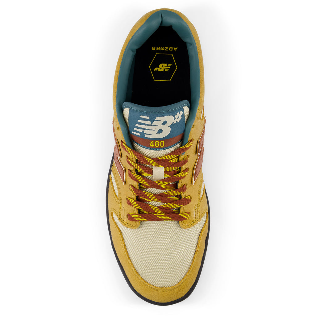 A yellow and blue NB NUMERIC 480 TRAIL PACK BROWN RED sneaker on a white background.