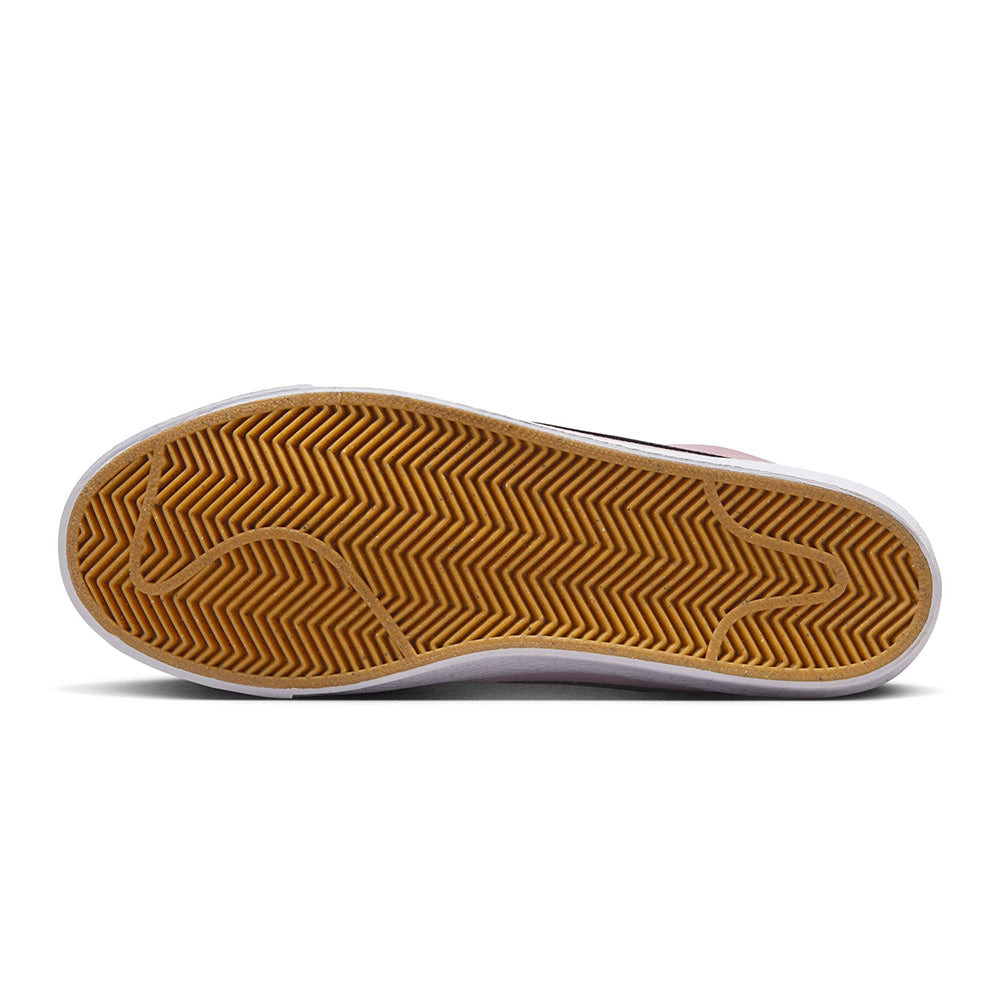 The image shows the bottom view of the NIKE SB BLAZER MID PINK FOAM/ANTHRACITE-WHITE-GUM YELLOW, featuring a gum sole with herringbone tread for traction and Zoom Air cushioning, offering skateboarders comfort and grip.