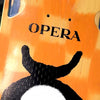 Close-up of an orange skateboard made from North American Maple with the word "OPERA" and a graphic of a turtle on it, shot from above.