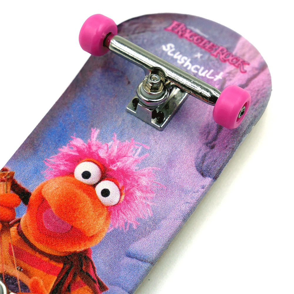 Close-up of the SLUSHCULT X FRAGGLE FINGERBOARD GOBO by SLUSHCULT, featuring a Fraggle Rock character design, pink wheels, and silver trucks—an ideal starter fingerboard for beginners.