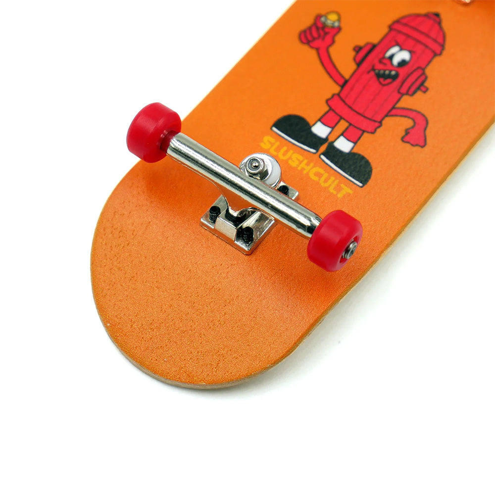 Close-up of the SLUSHCULT "GROM" SERIES 009 FINGERBOARD HYDRANT, featuring an orange deck, red wheels, and a cartoon fire hydrant graphic—ideal for beginner fingerboarders.