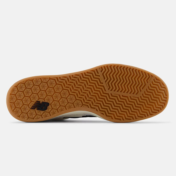 Bottom view of a NB NUMERIC NB NUMERIC 440 HIGH V2 WHITE / BLACK skate shoe sole showing a gum-colored rubber outsole with a chevron grip pattern and the NB NUMERIC logo.
