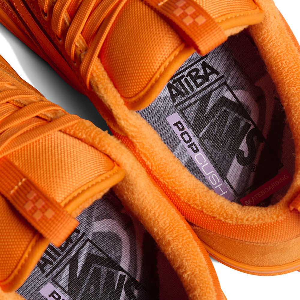 Close-up of two orange VANS X ATIBA SKATE OLD SKOOL 36+ SOLAR shoes featuring textured fabric and insoles labeled "Atiba," "Vans," "PopCush," and "Skateboarding.