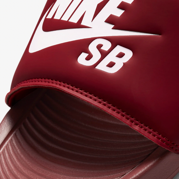 A red Nike SB Victor One slide in team red with a white Nike logo.