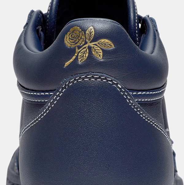 A close up of a CONVERSE CONS SAGE FASTBREAK PRO OBSIDIAN/NAVY shoe with a rose on it.
