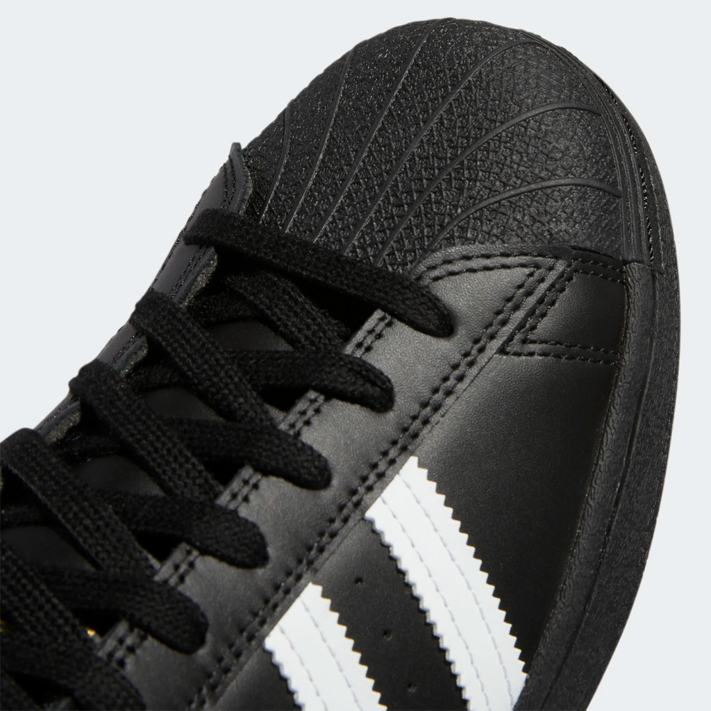 A close up of black and white ADIDAS SUPERSTAR ADV CORE BLACK / FLAT WHITE sneakers.