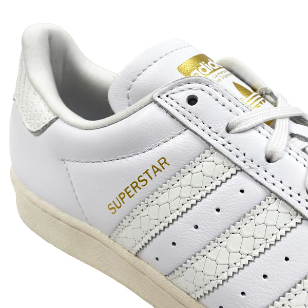 A pair of ADIDAS SUPERSTAR ADV WHITE / GOLD sneakers.