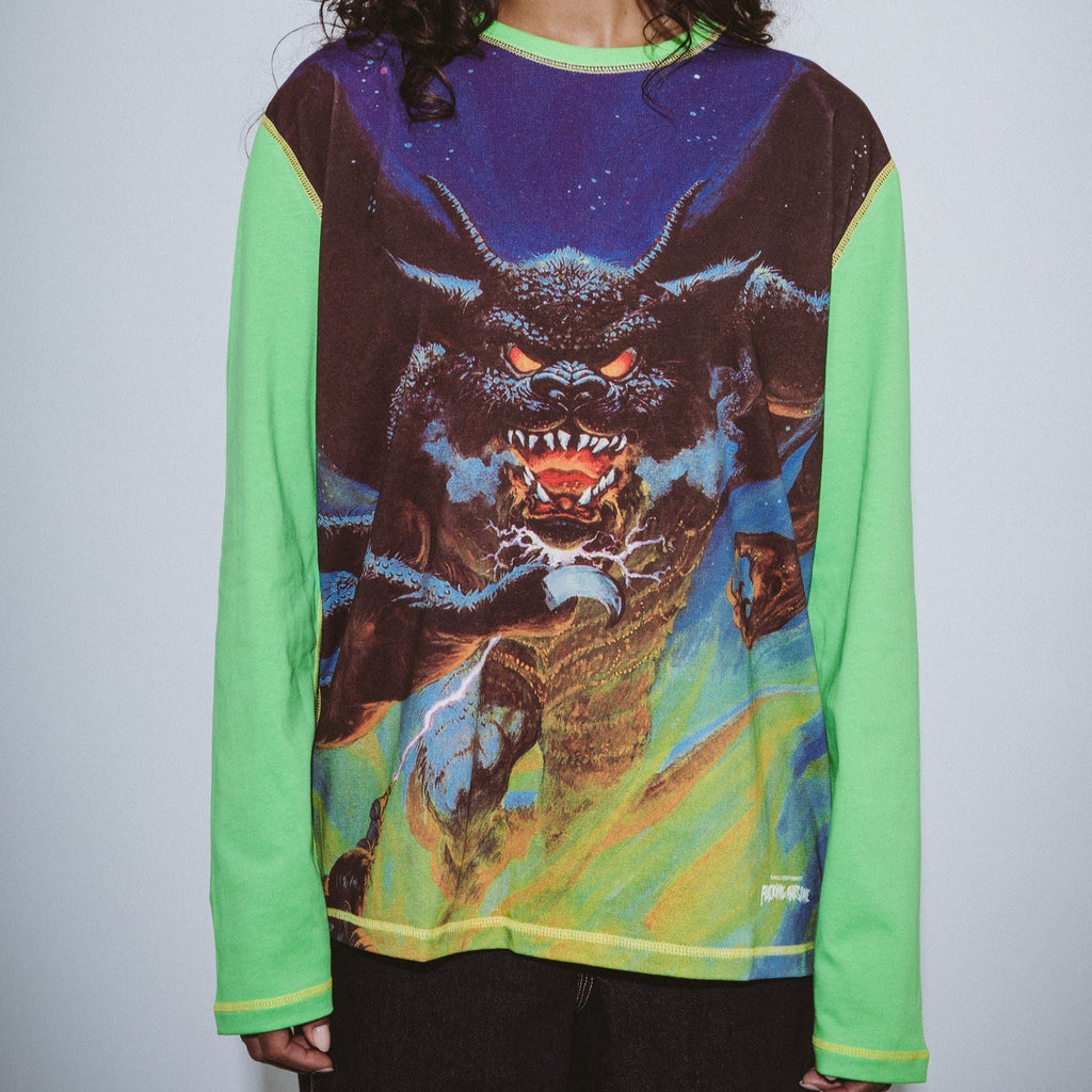 A woman wearing a green long-sleeved shirt with an image of a dragon, looking completely badass and rocking her "FUCKING AWESOME BETTER HALF L/S TEE GREEN" from the brand FUCKING AWESOME.