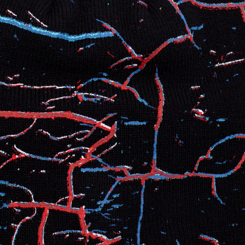 A close up of a HOCKEY black sock with red, blue, and green paint on it.