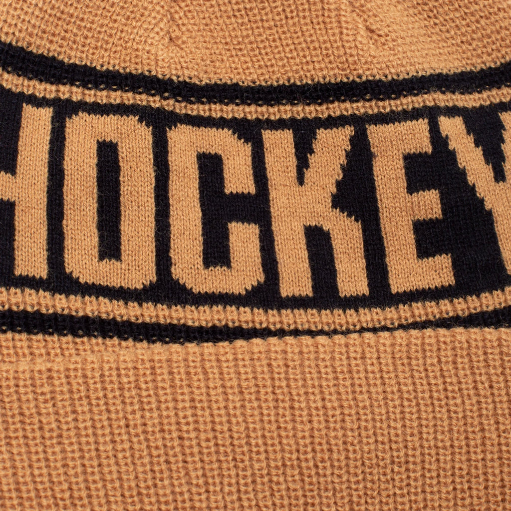 A blue woven HOCKEY beanie with the word HOCKEY on it.
