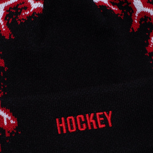 A close up of the word "hockey" embroidered in red on the cuff of the beanie.