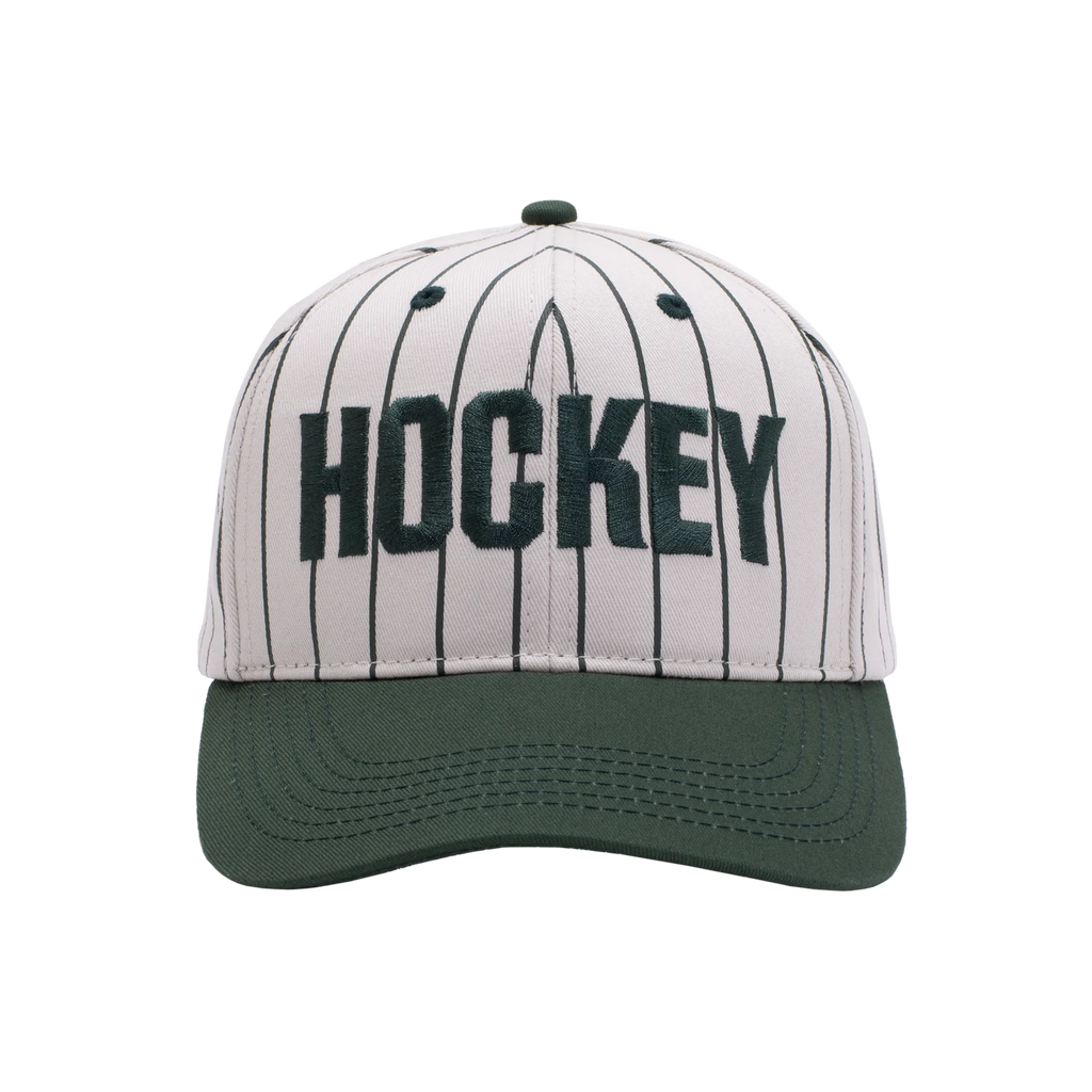 A cream baseball style hat with dark green stripes and brim, with the word "Hockey" embroidered across the front.